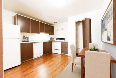A kitchen with brown cabinets and a white fridge.