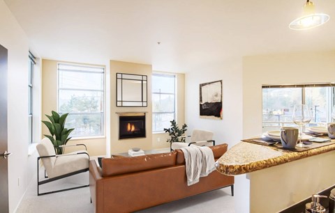 A modern living room with a fireplace and a brown couch.