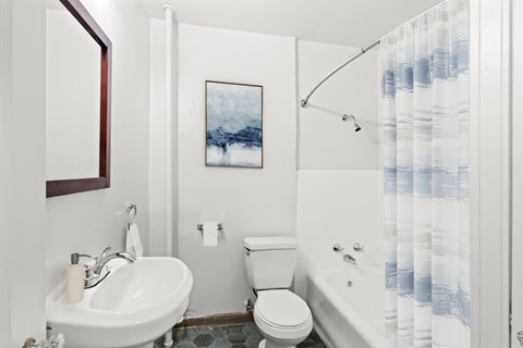 A bathroom with a white sink, toilet, and bathtub.