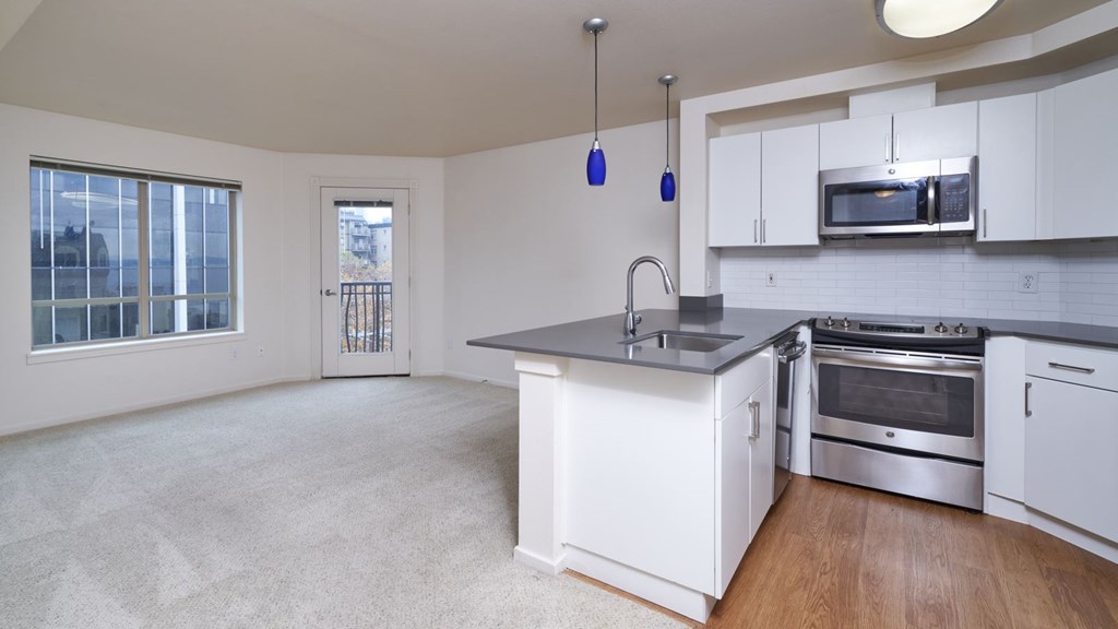 A kitchen with white cabinets and a large island.