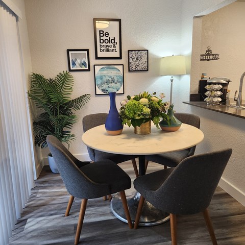 A dining room with a round table and chairs.