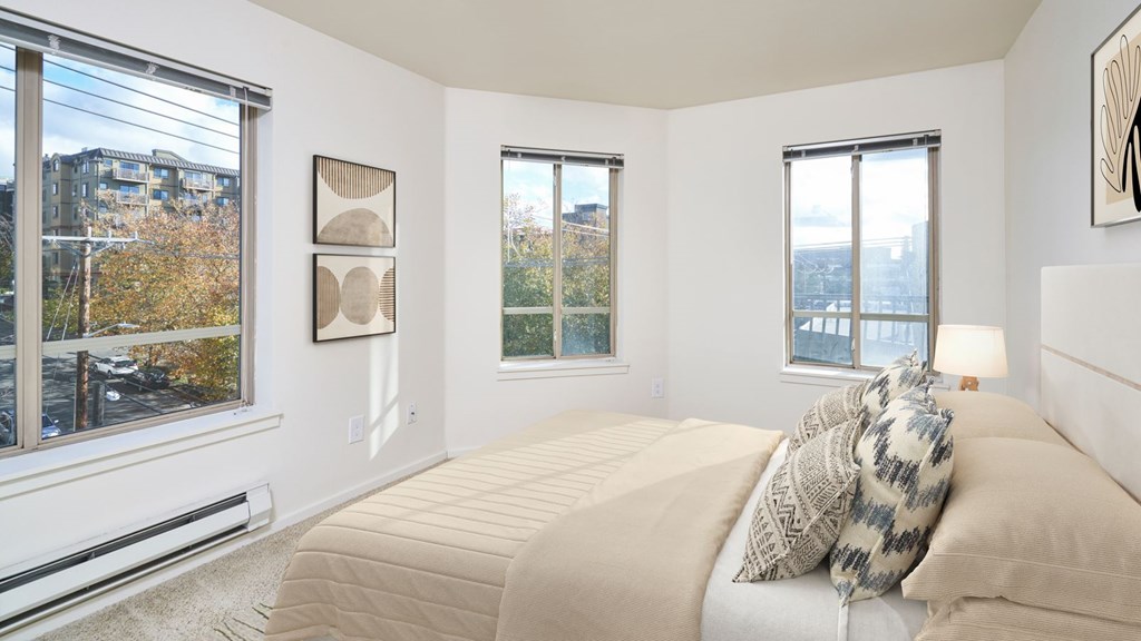 A bedroom with a large bed and a view of the city.