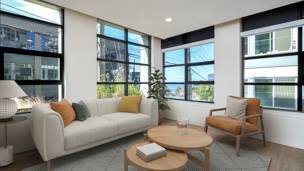 A living room with a white couch, a wooden coffee table, and a chair.