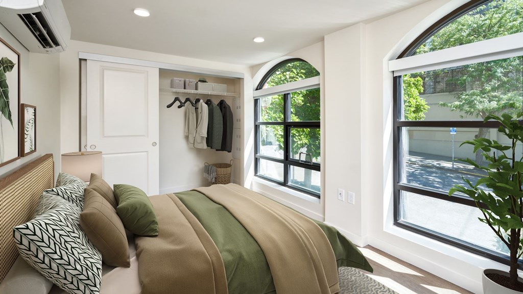 A bedroom with a large bed and a window overlooking a street.