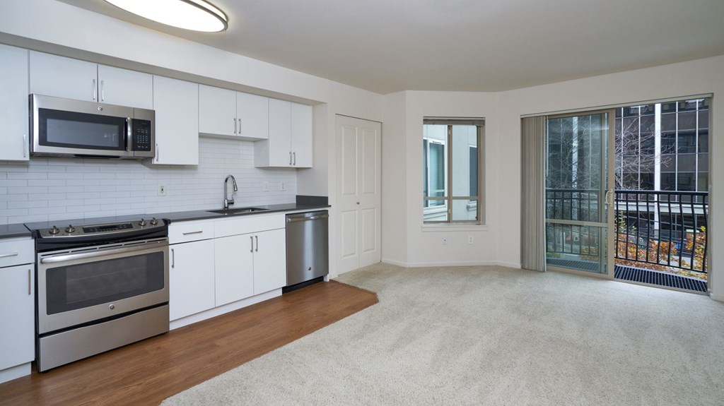 A kitchen with white cabinets and a stainless steel oven.