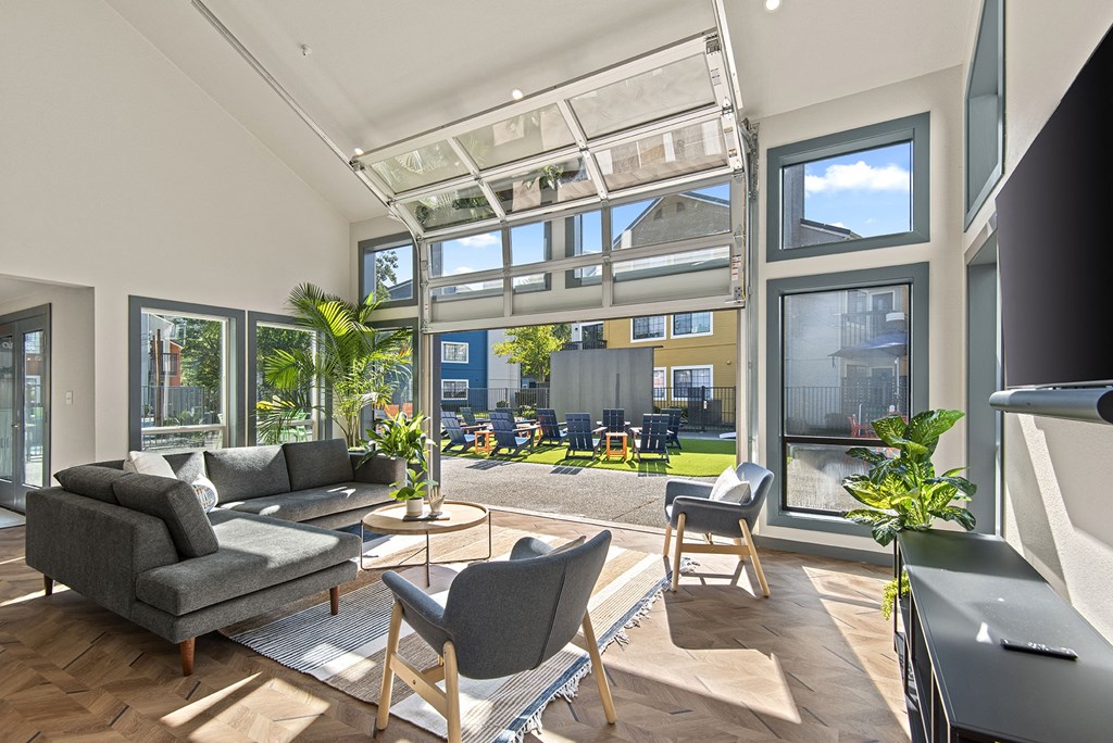 a living room with a couch and chairs in front of a large window