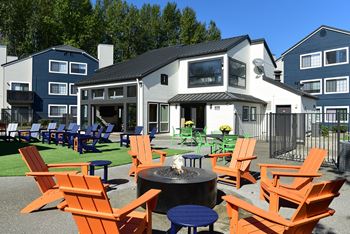 an outdoor patio with chairs and a fire pit