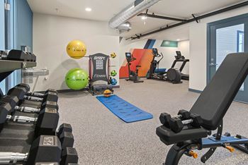 a gym with cardio equipment and weights on the floor of a building
