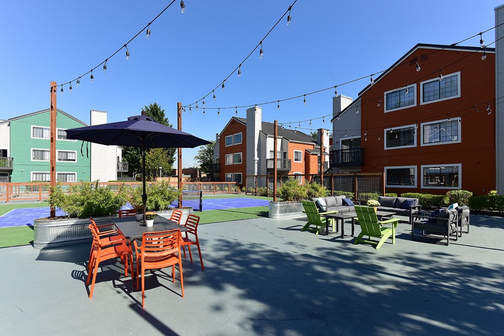 an outdoor patio with tables and chairs and buildings in the background
