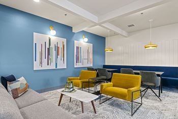 a living room with blue walls and yellow chairs