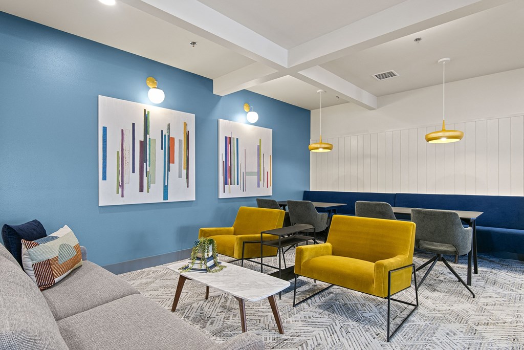 a living room with blue walls and yellow chairs