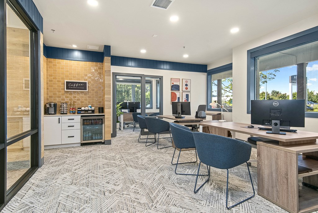 a conference room with desks and chairs and a computer
