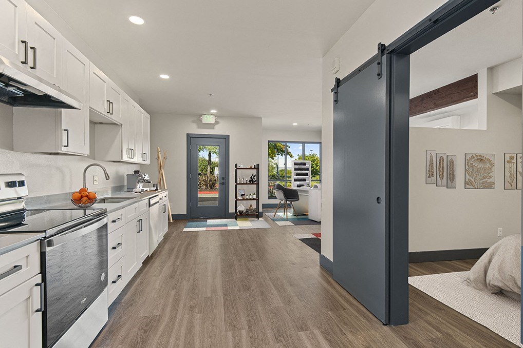 a kitchen with white cabinets and a black refrigerator