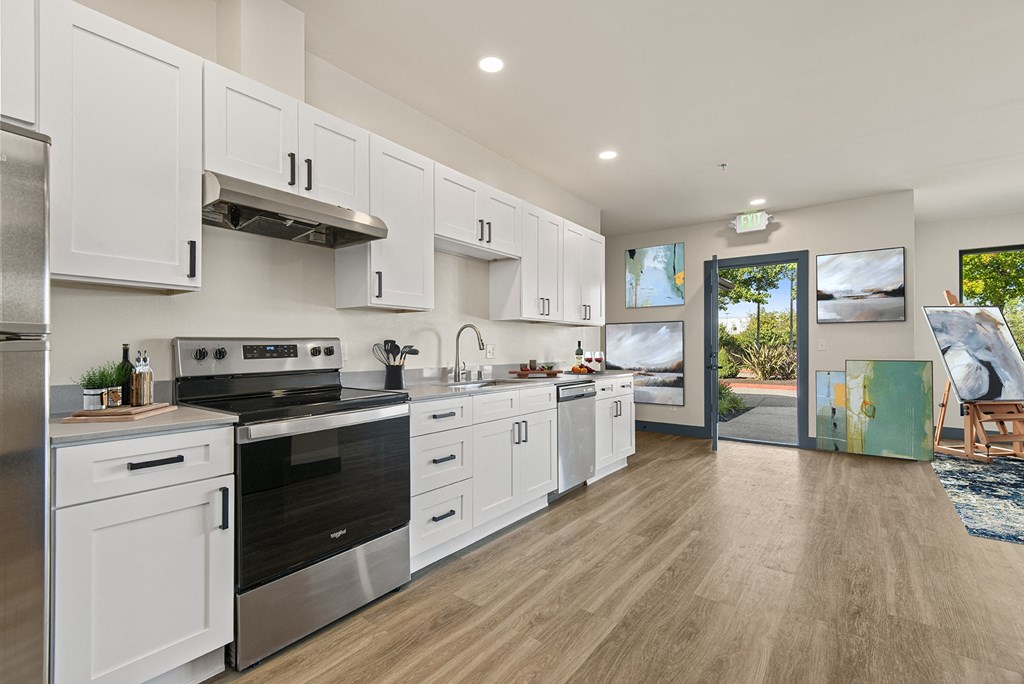 an open kitchen with white cabinets and stainless steel appliances