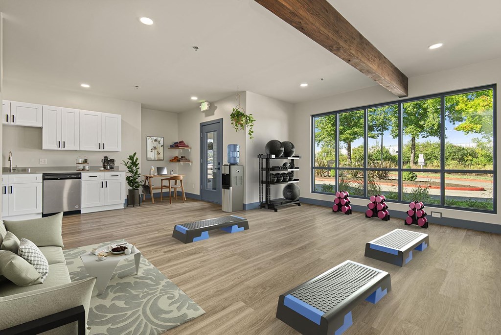 a spacious living room with a fitness center and a large window