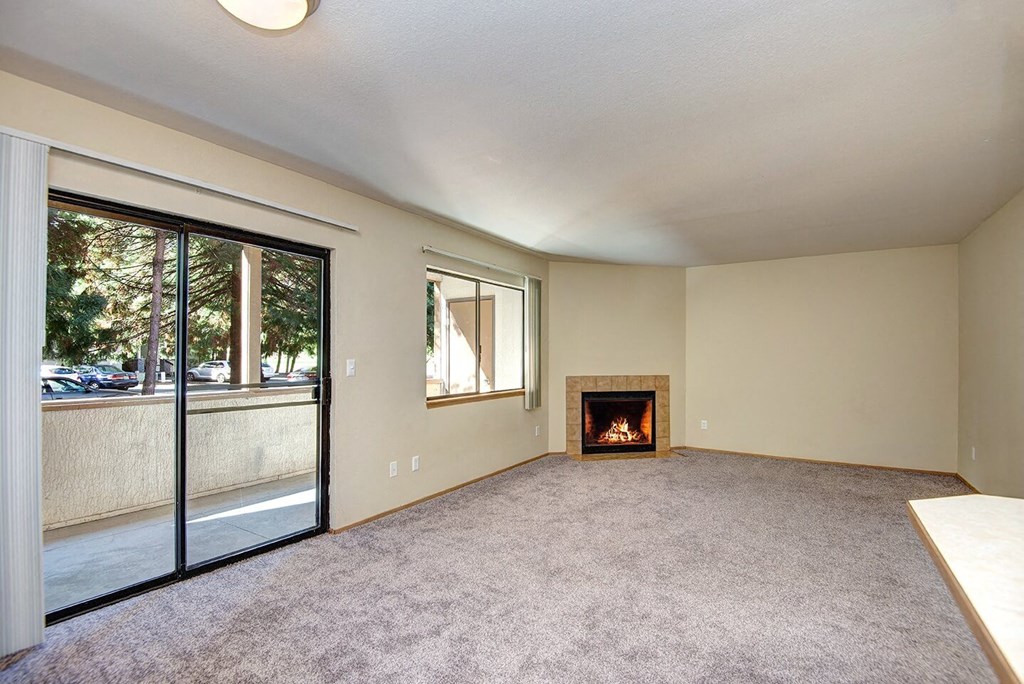 A room with a fireplace and sliding glass doors. at Autumn Village, Washington