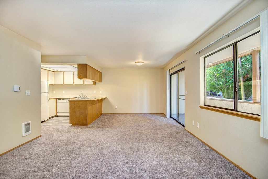 A large, empty room with a kitchen area in the background. at Autumn Village, Milton