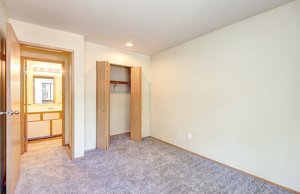 A room with a carpeted floor and a doorway leading to another room. at Autumn Village, Washington, 98354