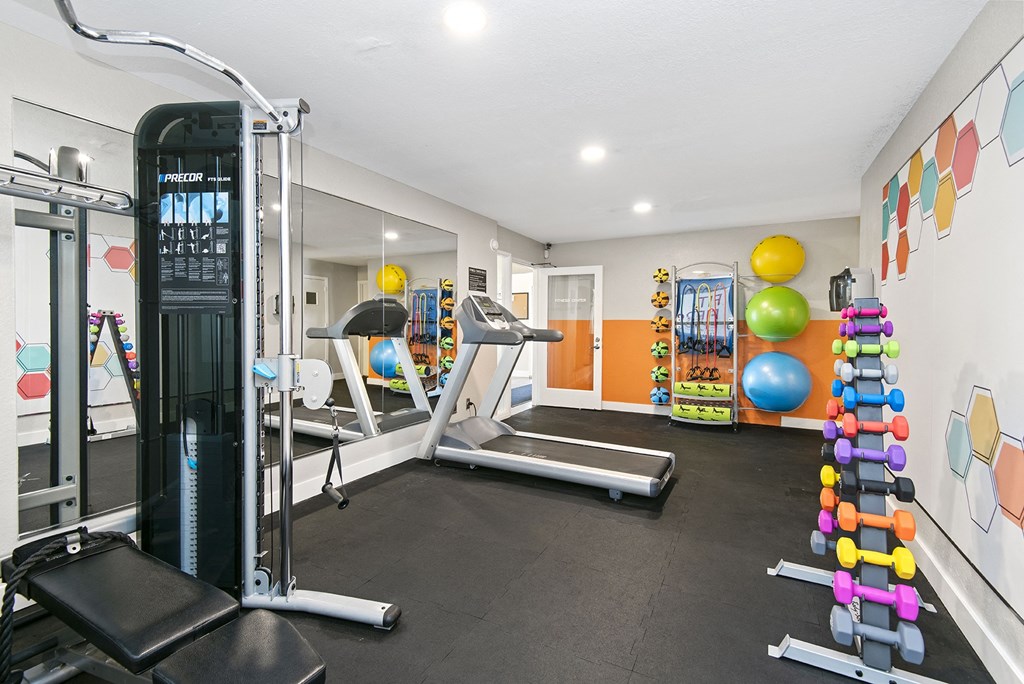 a gym with a treadmill and weights