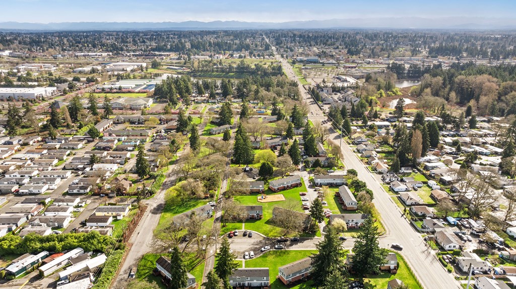 A bird's eye view of a residential area with houses, trees, and roads.