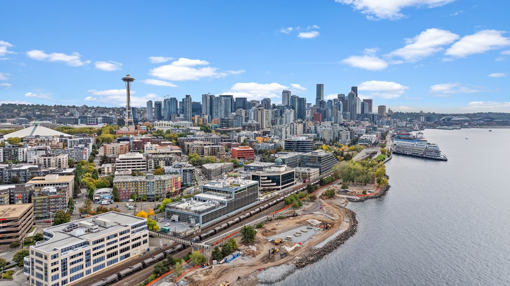 A cityscape with a large body of water and a boat in it.