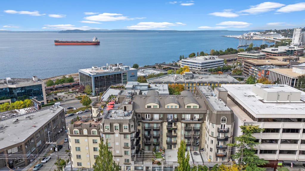 A large ship is in the water near a city.