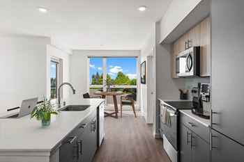 an open kitchen and living room with a view of a balcony