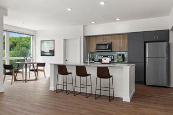 a kitchen with a large island with three bar stools