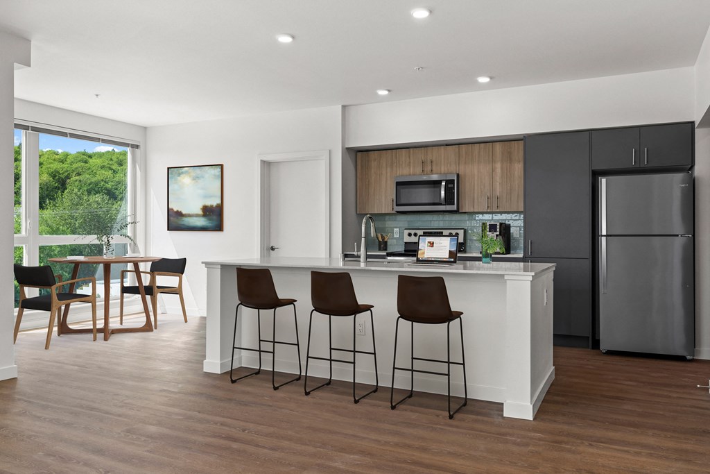 a kitchen with a large island with three bar stools