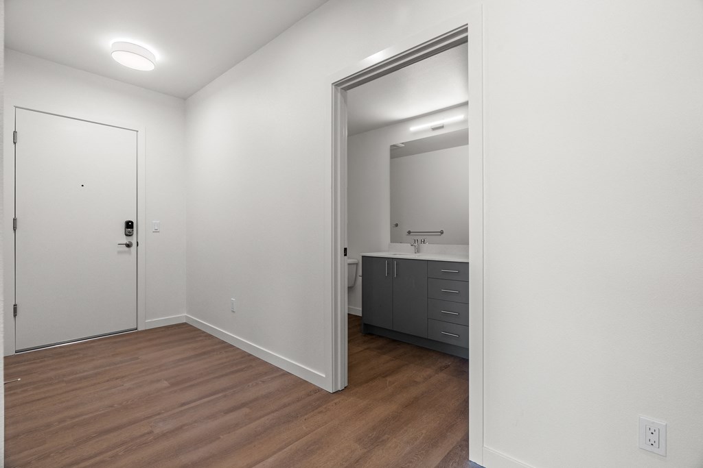 an empty room with a mirror and a bathroom