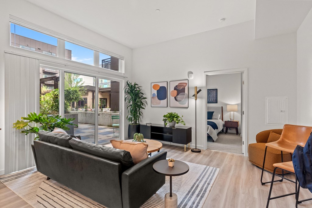 a living room with a couch and a coffee table and large windows