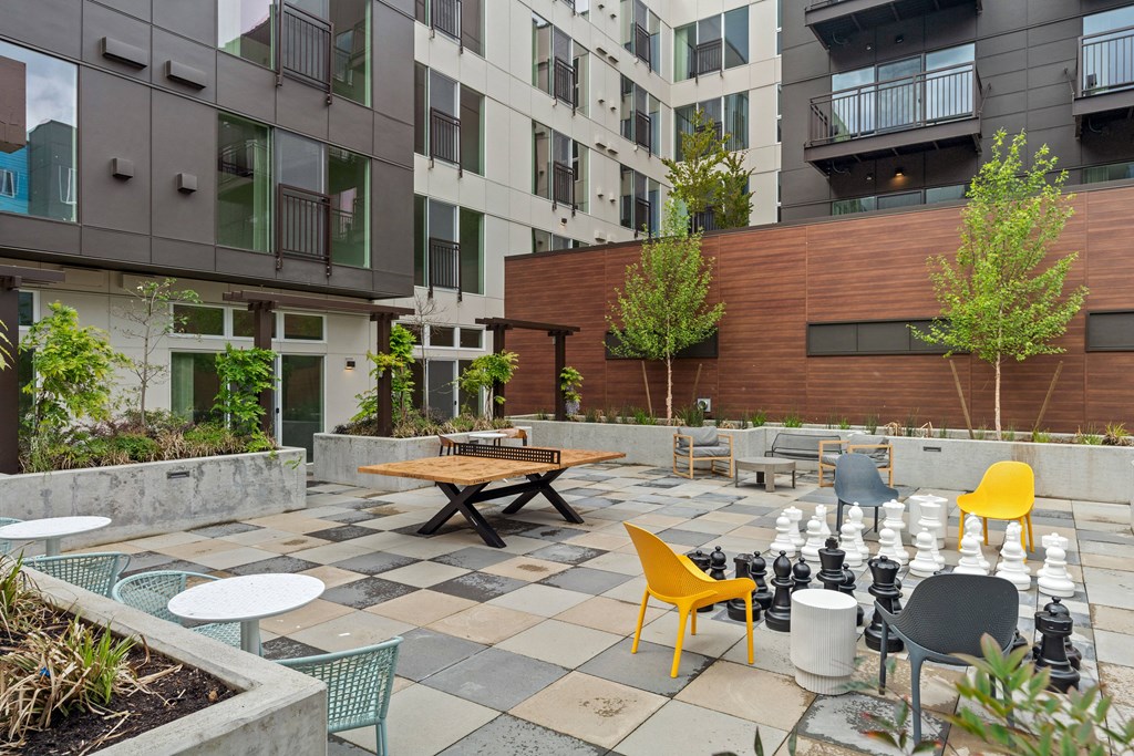 an outdoor patio with tables and chairs at an apartment complex