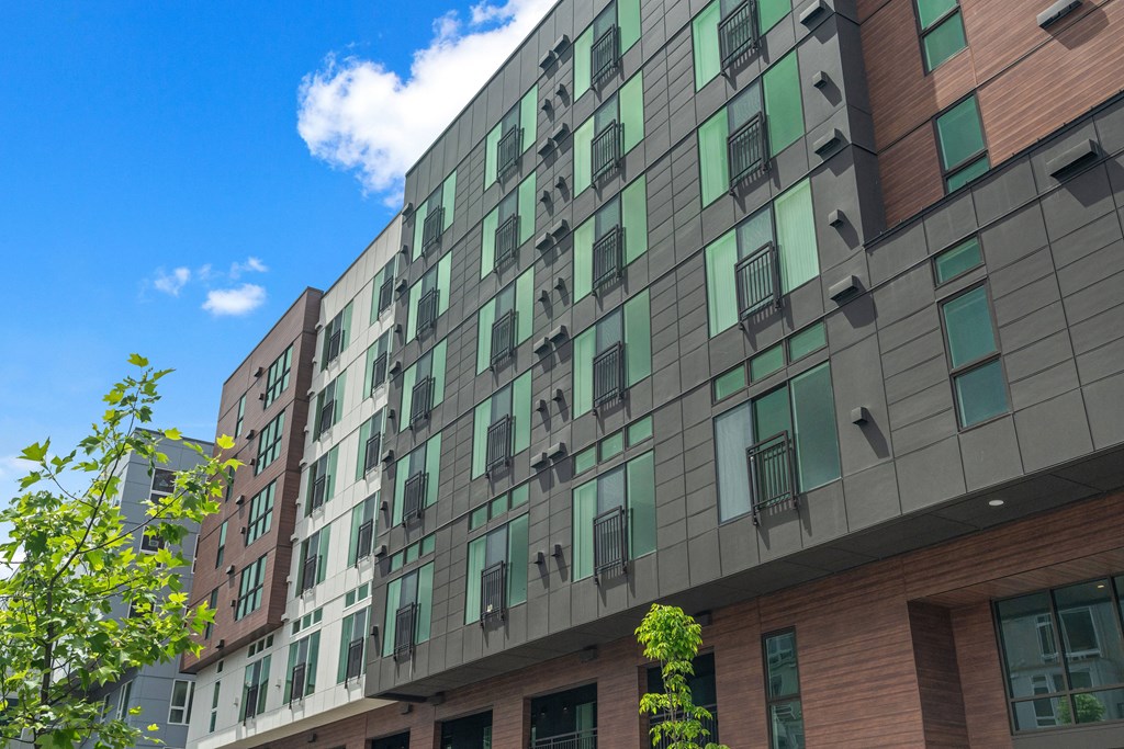 a tall building with green windows and a blue sky
