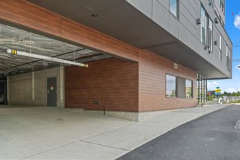 the side of a building with a door and a sidewalk