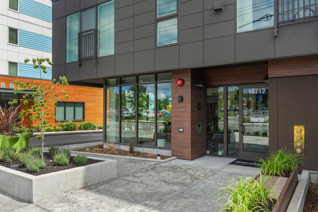 front entrance of a building with glass doors and a sidewalk