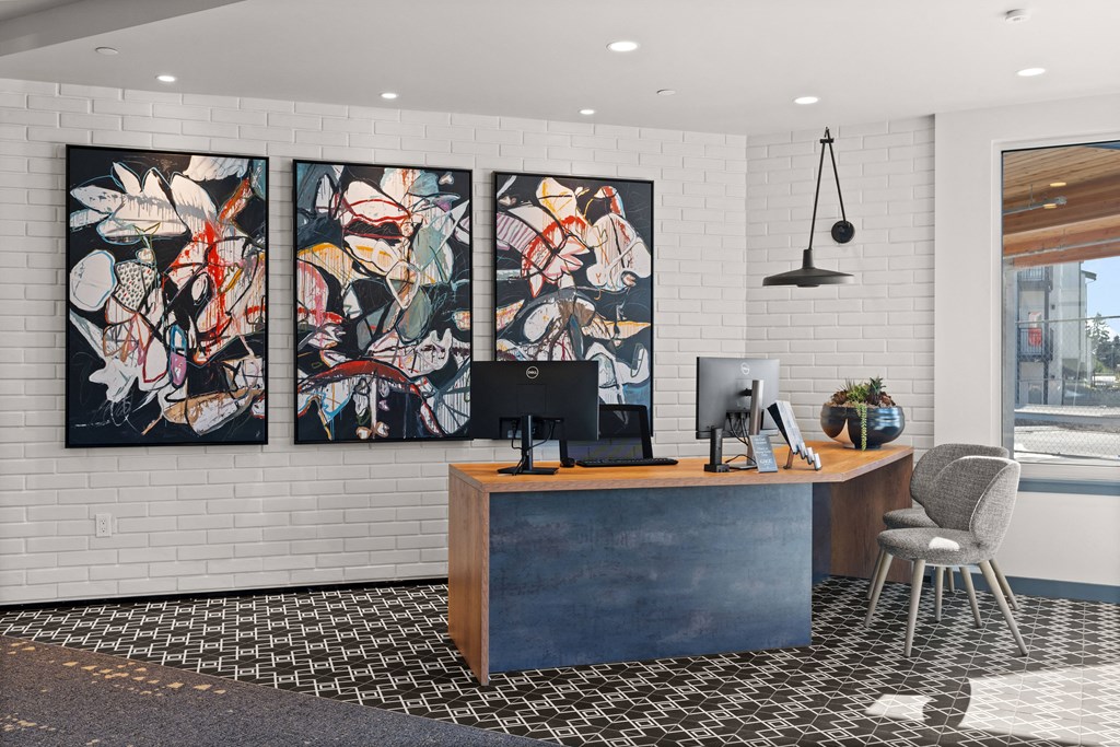 an office with three paintings on the wall and a desk with a computer