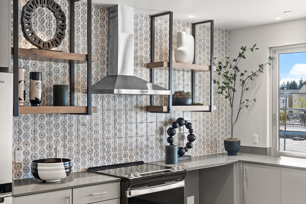 a kitchen with a stove and shelves on the wall