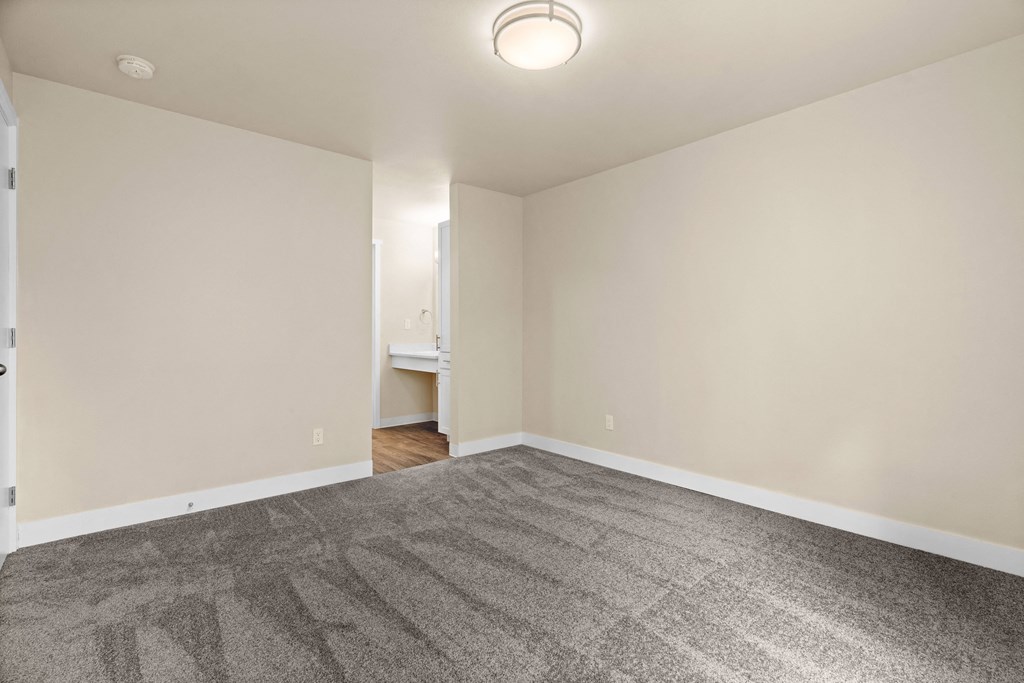 an empty living room with carpet and white walls