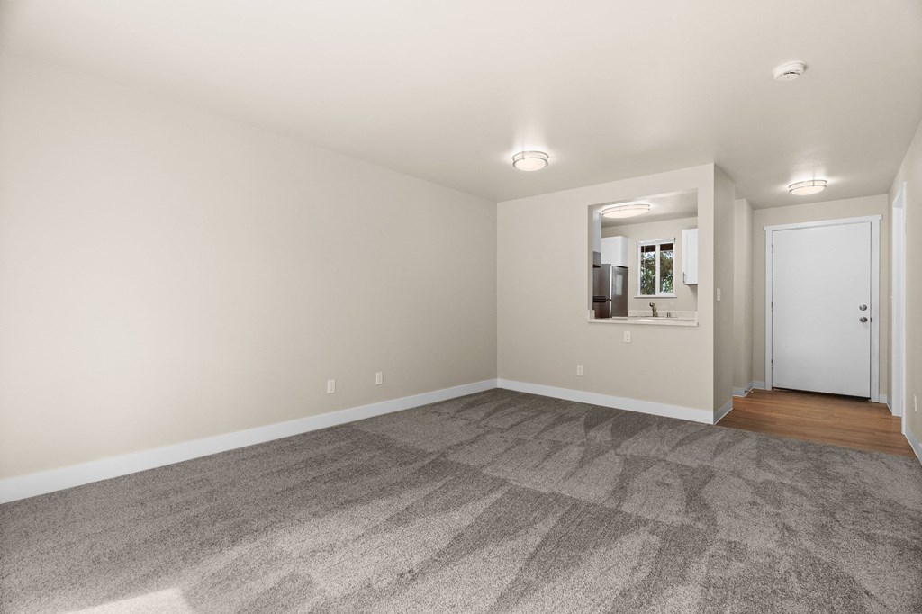 a living room with carpet and a door to a bathroom