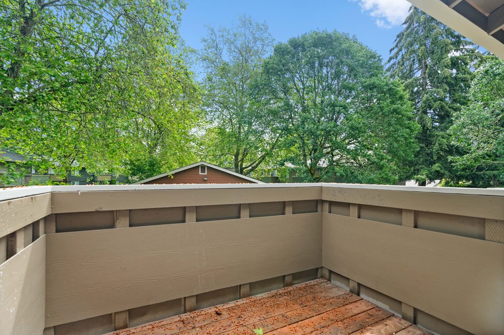 the view from the top of a balcony overlooking the trees