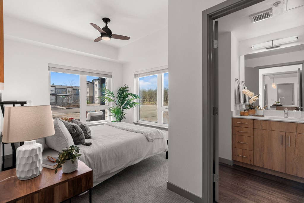 a bedroom with a bed and a large window and a mirror at Gage On Sixth, Tacoma