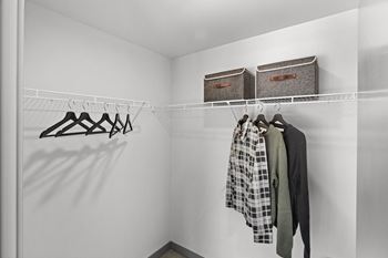 a walk in closet with two baskets on the wall and clothes hanging on a rack at Gage On Sixth, Tacoma