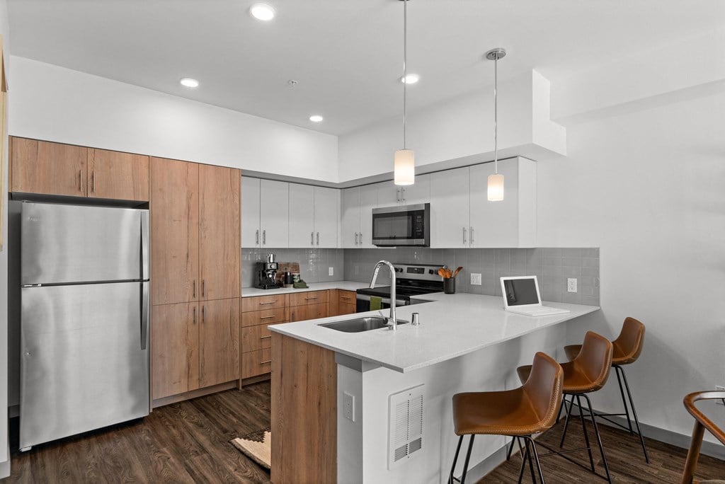a kitchen with a large island and a stainless steel refrigerator at Gage On Sixth, Tacoma Washington