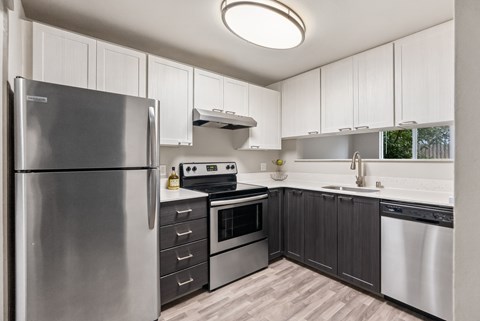 A modern kitchen with a stainless steel refrigerator and a stove top oven.