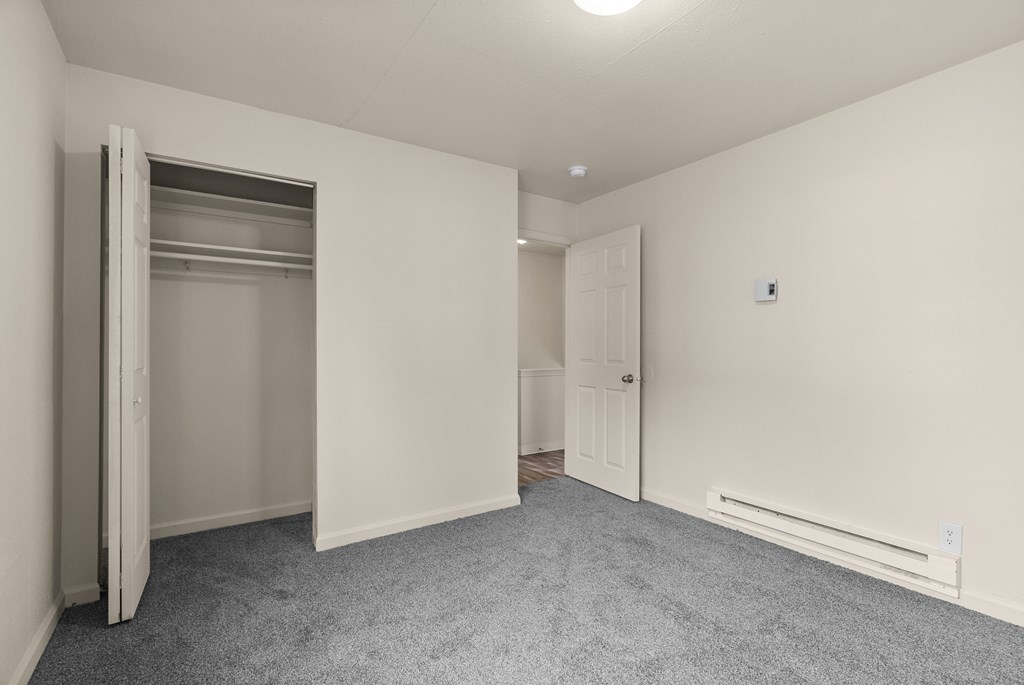 A room with a grey carpet and white walls.