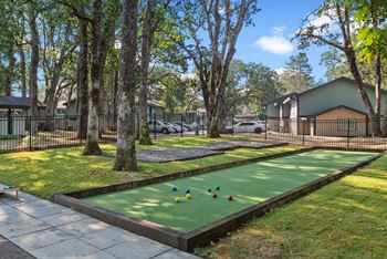 A miniature golf course with a green surface and yellow balls.