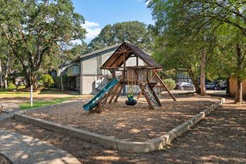 A playground with a slide and a swing set.