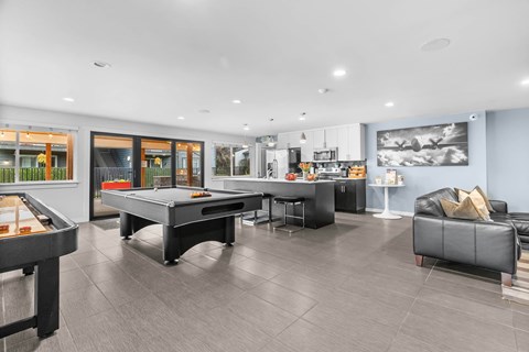 A modern living room with a pool table and a couch.