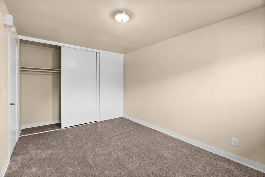 A room with a carpeted floor and a ceiling light.