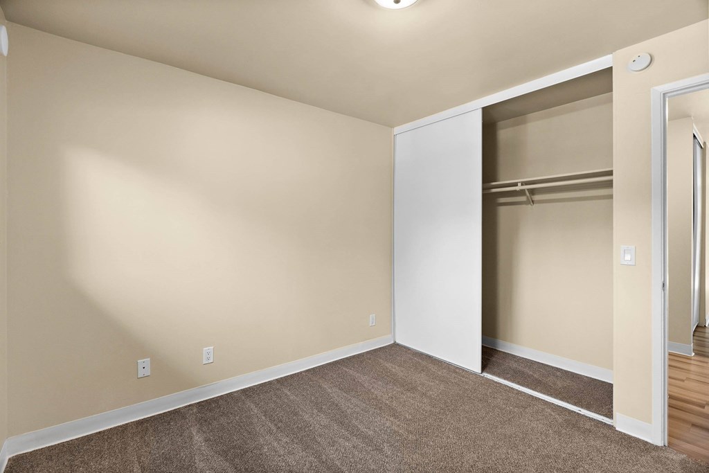 A room with a white door and a carpeted floor.
